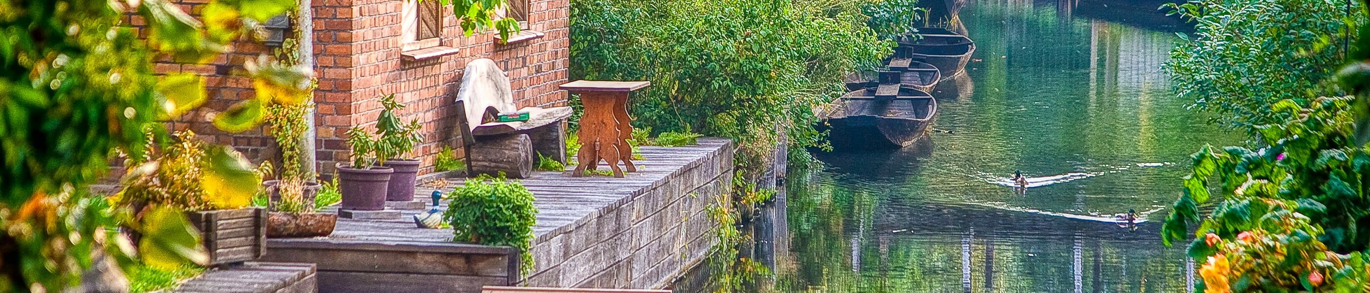 Holzterrasse am Kanal mit Sitzplatz und Booten