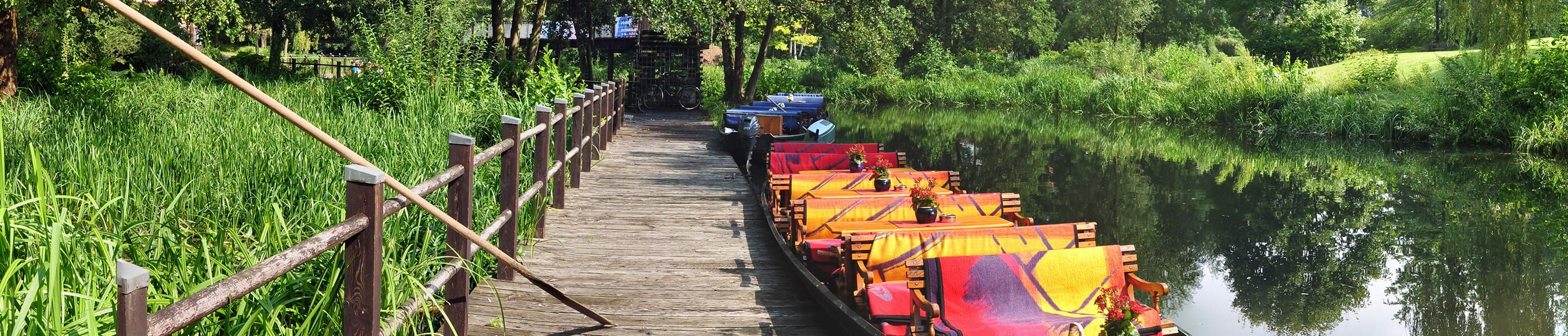 Spreewaldkanal mit angelegtem Ausflugsboot und Steg